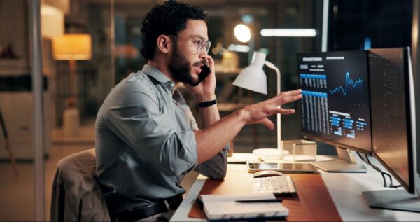 a man sits at a computer at night
