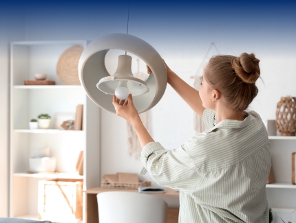 Woman replacing a light bulb