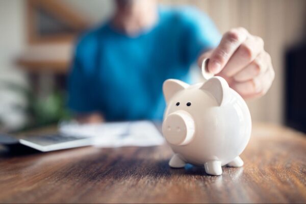 a person putting a coin into a piggybank
